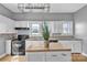 Bright kitchen with white cabinets, central island and black appliances at 34 Lee Rd, Stony Point, NC 28678