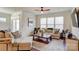 Living room with hardwood floors, beige sofa, and large windows at 3936 Rothwood Ln, Harrisburg, NC 28075