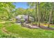 Spacious backyard with a lush green lawn, mature trees, and a deck at 4145 Wall St, Charlotte, NC 28209