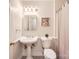 Bathroom features a pedestal sink, framed mirror, toilet, and a shower at 4145 Wall St, Charlotte, NC 28209