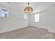 Well-lit bedroom featuring neutral carpet, large windows, and modern lighting at 425 Delburg Mill Alley Dr, Davidson, NC 28036