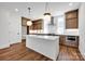 Modern kitchen featuring an island, wooden cabinets, stone countertops, and stainless steel appliances at 425 Delburg Mill Alley Dr, Davidson, NC 28036