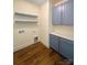 Laundry room with blue cabinets, wood floors, and open shelving at 425 Delburg Mill Alley Dr, Davidson, NC 28036