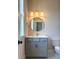 Elegant bathroom featuring a gray vanity, round mirror, sconce lighting, and modern fixtures at 429 Delburg Mill Alley Dr, Davidson, NC 28036