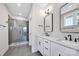 Modern bathroom featuring dual sinks with black fixtures, a large mirror, and a glass-enclosed shower at 429 Delburg Mill Alley Dr, Davidson, NC 28036