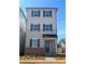 Charming three-story home with gray siding, brick accents, dark shutters, and inviting front entrance at 429 Delburg Mill Alley Dr, Davidson, NC 28036