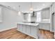 Kitchen with island, shaker style cabinets, and stainless hood at 429 Delburg Mill Alley Dr, Davidson, NC 28036
