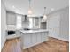 Bright kitchen features gray cabinets, pendant lighting, stainless appliances, and a large center island at 429 Delburg Mill Alley Dr, Davidson, NC 28036