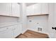 The large laundry room provides plenty of storage and functionality with white cabinets and laminate floors at 429 Delburg Mill Alley Dr, Davidson, NC 28036