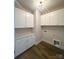 Well-organized laundry room featuring white cabinets, laminate flooring, and ample counter space at 429 Delburg Mill Alley Dr, Davidson, NC 28036
