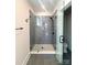Sleek walk-in shower with gray tiling, glass door, and modern fixtures at 429 Delburg Mill Alley Dr, Davidson, NC 28036