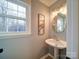 Charming powder room with pedestal sink and decorative art at 4440 Beechaven Dr, Rock Hill, SC 29732