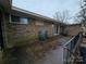 Concrete patio with brick wall and two green chairs at 5009 Highlake Dr, Charlotte, NC 28215