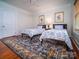 Bedroom with two twin beds, blue rug, and hardwood floors at 523 W 2Nd Ave, Gastonia, NC 28052