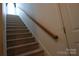 Carpeted staircase with wooden handrail at 5375 Josephine Sw Ln, Concord, NC 28027