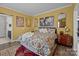 Cheerful primary bedroom with yellow walls, decorative artwork, and a patterned bedspread at 645 Honey Dew Ln, Fort Mill, SC 29715