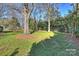 Landscaped backyard featuring mature trees and lush green grass at 6511 Newhall Rd, Charlotte, NC 28270