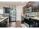 Modern kitchen with dark cabinetry, stainless steel appliances, and granite countertops at 6908 Agava Ln, Charlotte, NC 28215