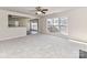 Living room with carpet, kitchen view, and large window at 7780 Orchard Park Cir, Harrisburg, NC 28075