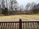 Open backyard view from deck, showing grassy area and trees at 7925 Tottenham Dr, Harrisburg, NC 28075