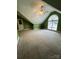 Large bonus room with vaulted ceiling, carpet, and an arched window at 7925 Tottenham Dr, Harrisburg, NC 28075