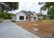 Newly built home with white siding, black windows, and a long driveway at Lot 1 Hoke W St, Landis, NC 28088