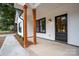 Modern farmhouse style front porch with wood columns and black door at Lot 1 Hoke W St, Landis, NC 28088