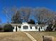 White ranch home with mature trees and stone walkway at 10512 Roseberry Ct, Charlotte, NC 28277