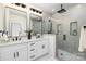 Modern bathroom with double vanity, large mirror and walk-in shower at 10605 S Hampton Dr, Charlotte, NC 28227