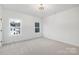 Bright bedroom with carpet, two windows, and a door at 10605 S Hampton Dr, Charlotte, NC 28227