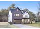 Modern farmhouse exterior with dark brick and white accents, attached garage, and inviting front porch at 10605 S Hampton Dr, Charlotte, NC 28227