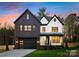 Striking two-story home with a modern black and white facade, black garage door, and manicured lawn at 10605 S Hampton Dr, Charlotte, NC 28227