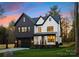 Striking two-story home with a modern black and white facade, black garage door, and manicured lawn at 10605 S Hampton Dr, Charlotte, NC 28227