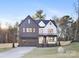 Two-story modern farmhouse with dark brick and white siding, attached garage, and landscaped yard at 10605 S Hampton Dr, Charlotte, NC 28227