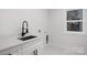 Clean laundry room with white cabinets and a modern sink at 10605 S Hampton Dr, Charlotte, NC 28227