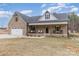 Charming brick home with a covered front porch and attached two-car garage, all under a classic gabled roof at 1076 Furnace Rd, Iron Station, NC 28080