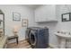 Functional laundry room with modern washer and dryer units, storage cabinets, and a sink at 1076 Furnace Rd, Iron Station, NC 28080