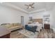 Bright main bedroom featuring a tray ceiling, ceiling fan, sitting area, and decorative rug at 1076 Furnace Rd, Iron Station, NC 28080