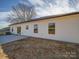 The side and rear of this home feature vinyl siding, a small patio, and a spacious yard at 1112 Wiscassett St, Albemarle, NC 28001