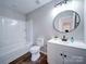 Bathroom featuring a shower-tub combo, round mirror, and modern vanity at 1112 Wiscassett St, Albemarle, NC 28001