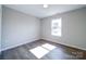 Bright bedroom featuring a large window, neutral walls, and wood flooring at 1112 Wiscassett St, Albemarle, NC 28001