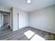 This bedroom features luxury vinyl plank flooring, neutral walls, closet with sliding doors, and natural light at 1112 Wiscassett St, Albemarle, NC 28001