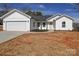 Charming single-story home featuring white siding, attached garage, and a well-maintained lawn at 1112 Wiscassett St, Albemarle, NC 28001