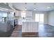 Modern kitchen with white cabinets, stainless steel appliances, island, and hardwood flooring at 1112 Wiscassett St, Albemarle, NC 28001