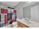 Clean bathroom with a shower/tub combo, wood vanity, and red shower curtain at 11906 Bending Branch Rd, Charlotte, NC 28227