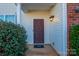 Front door entry with landscaping and light fixture at 11906 Bending Branch Rd, Charlotte, NC 28227