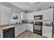 Kitchen with white cabinets, black appliances, and laminate flooring at 11906 Bending Branch Rd, Charlotte, NC 28227