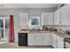 White kitchen cabinets, black appliances, and a corner sink with window above at 11906 Bending Branch Rd, Charlotte, NC 28227