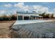 Gray metal barn-style home with triple garage doors and covered porch at 219 Mock Mill Rd, Statesville, NC 28677