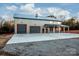 Gray metal barn-style home with triple garage doors and covered porch at 219 Mock Mill Rd, Statesville, NC 28677